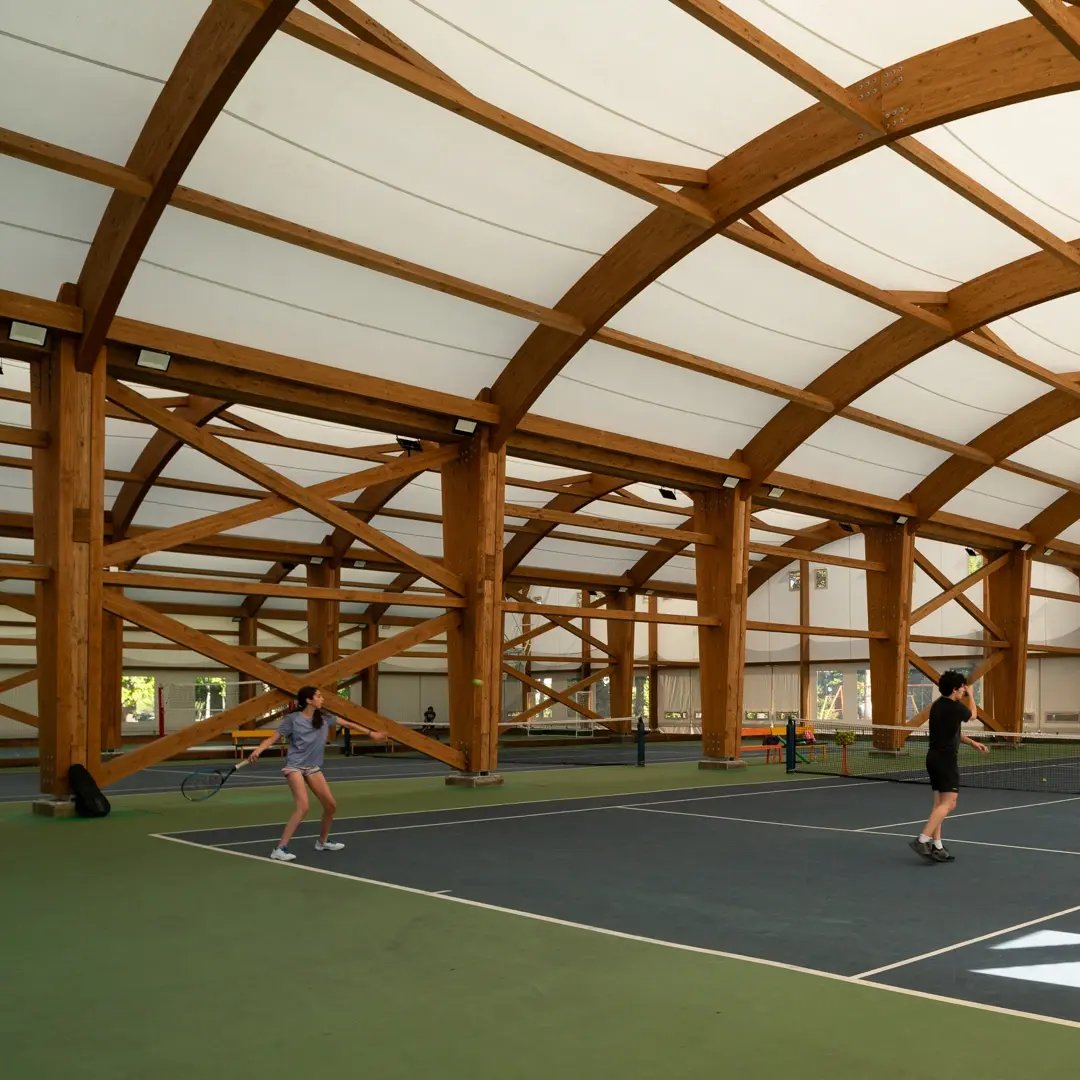Cancha deportiva cubierta con arquitectura textil en estructura de madera